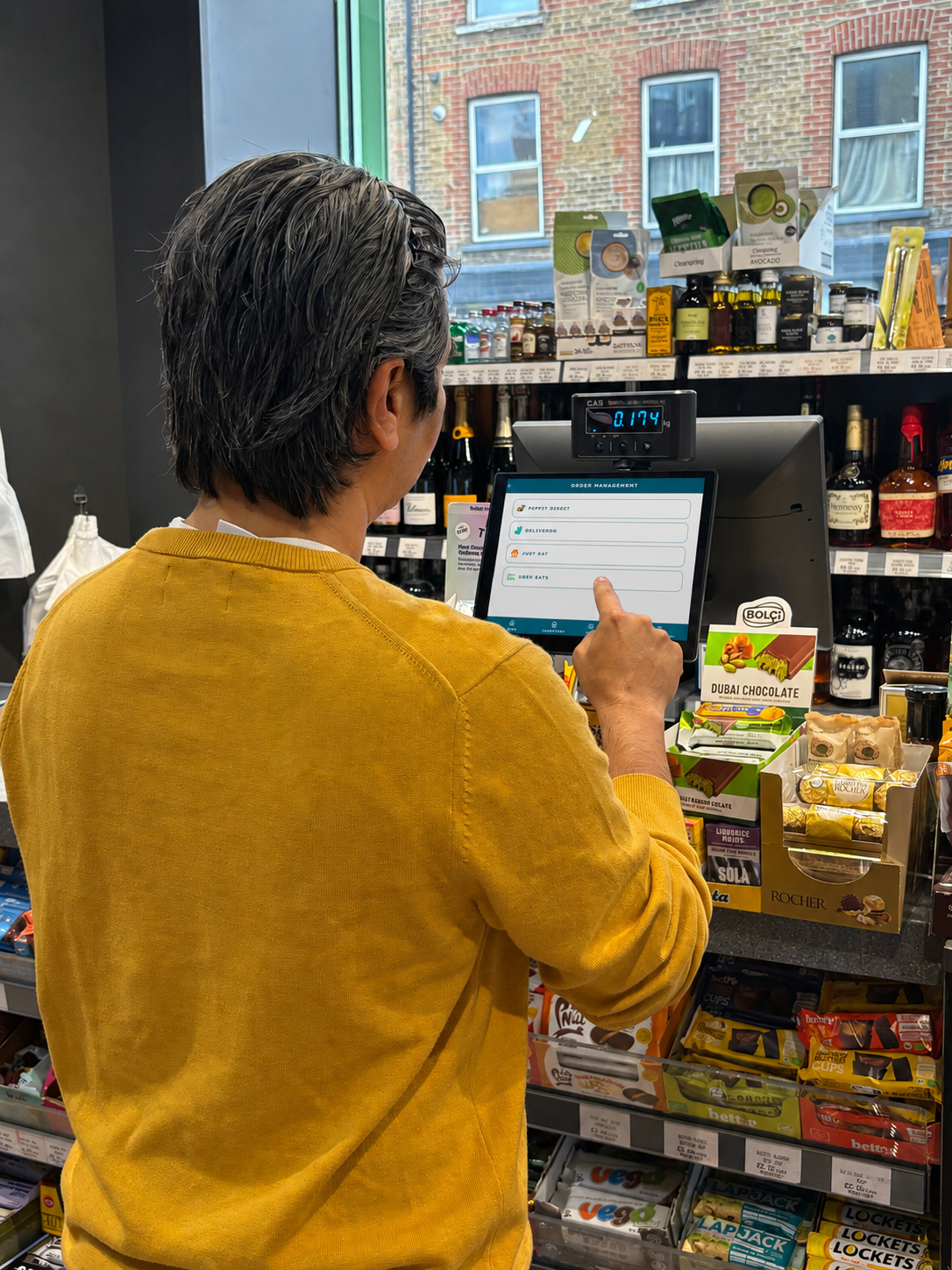 A shopkeeper looking at their phone with a confident, satisfied expression